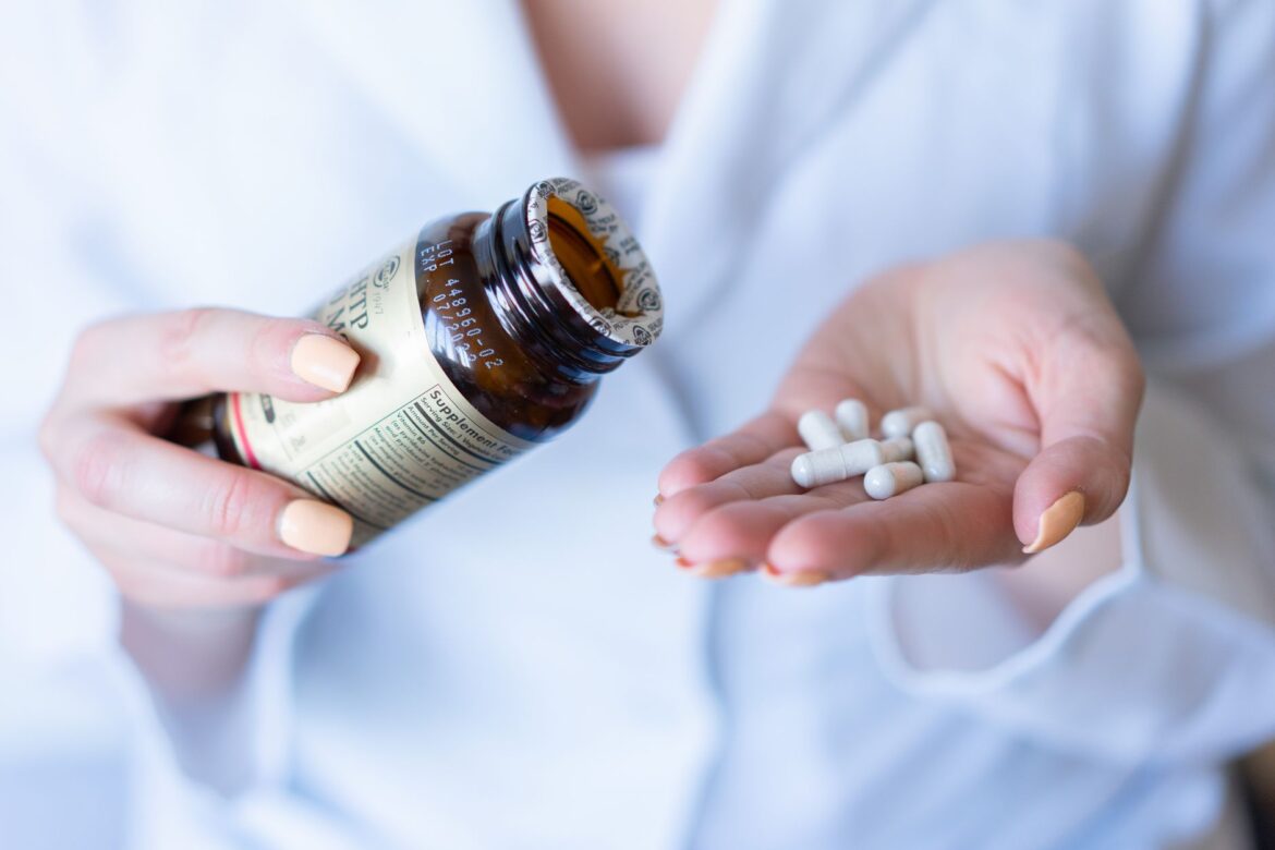 a woman holding pills and a bottle